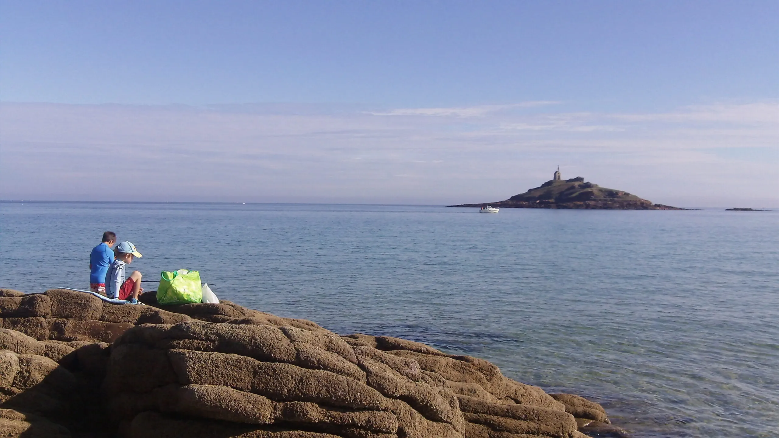Il mare con un’isola e un faro all’orizzonte