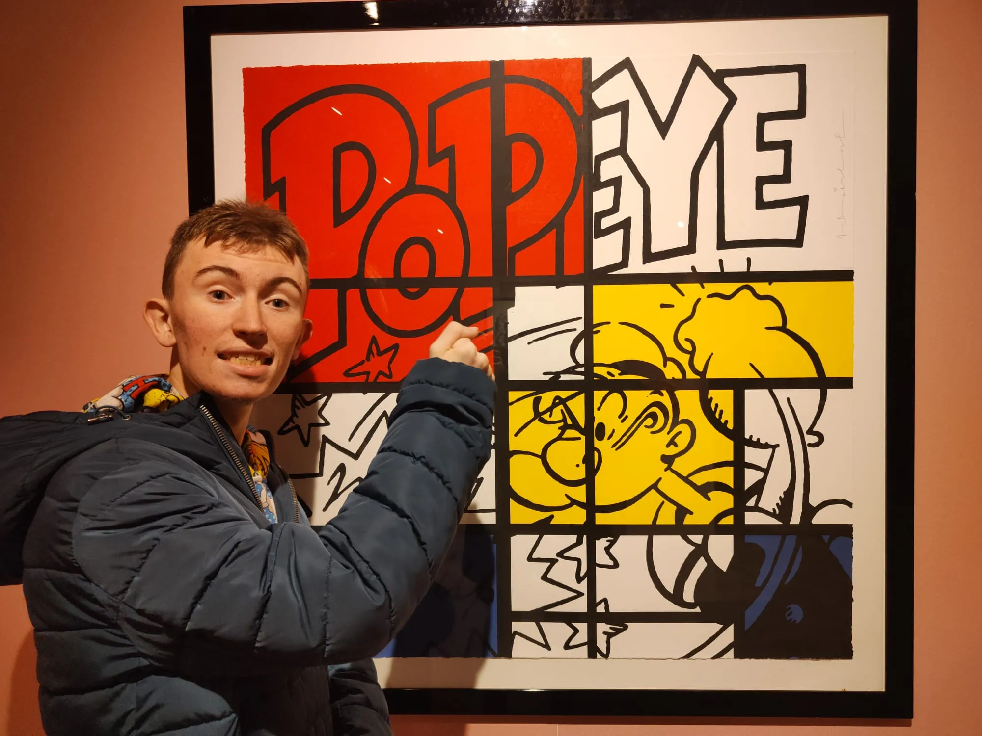 Ragazzo sorridente davanti a un quadro di Popeye